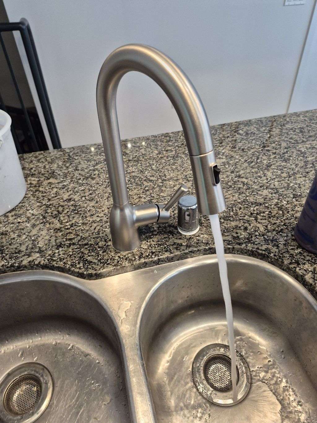Grifo de cocina extraíble funcionando sobre un fregadero de acero inoxidable durante la prueba final de un servicio en San Diego.